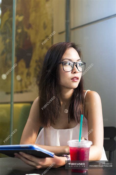 pretty asian girl in glasses with tablet — one person street stock