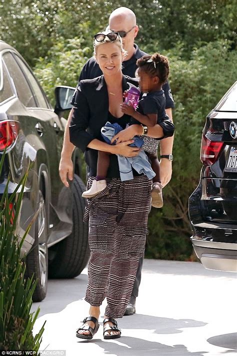 charlize theron carries daughter august around on her hip daily mail online