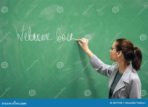 young teacher writing   board stock photo image  candid