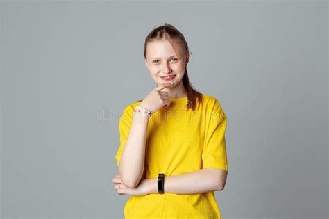 Smiling Teen Girl Looking At The Camera Touching Herself Face By Index