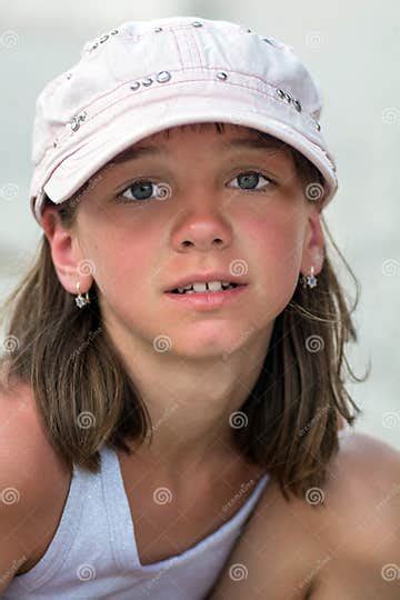 Portrait Of A Cute Tanned Girl With Big Beautiful Eyes In A Cap On A