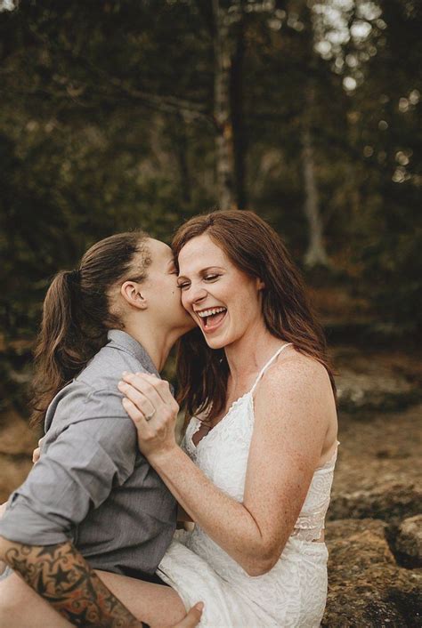lesbian engagement photo kissing on cliffs and waterfall