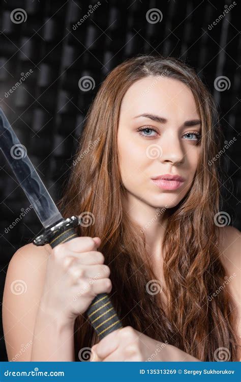 portrait of a naked woman with a katana in her hands stock image