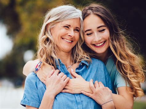 adult daughter hugs mom with long hair mother daughter photography
