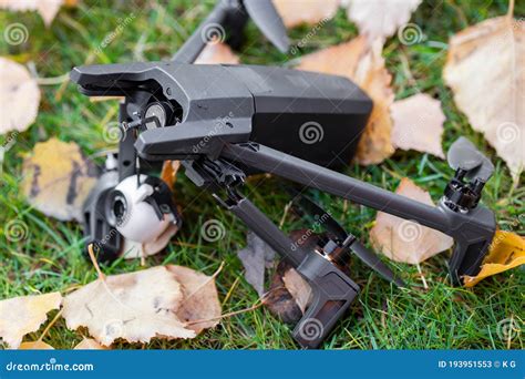broken black quadcopter drone uav lying  green grass lawn  ground