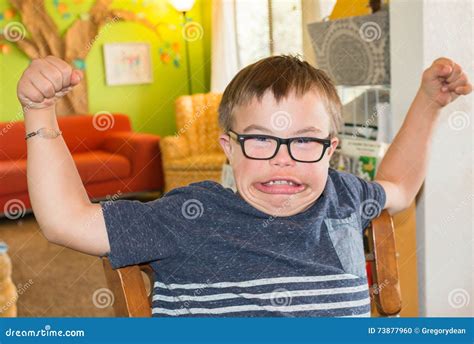 boy  downs syndrome flexing  muscles stock photo image  disability concept