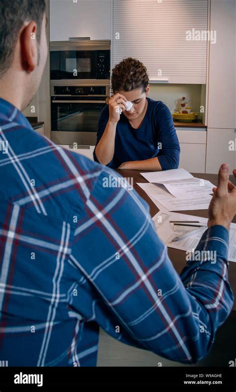 Unemployed Husband Reviewing The Bills And Wife Crying By Debts Stock