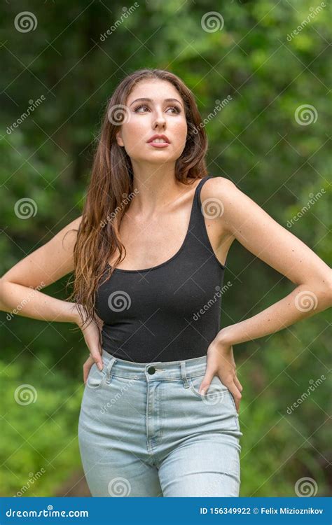 Attractive Young Woman Posing With Hands On Hips And Looking Up Away