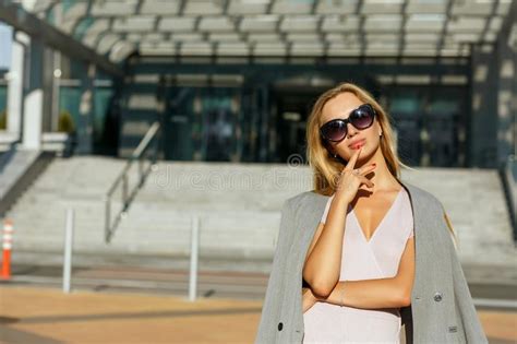 amazing blonde girl wearing sunglasses and sport apparel posing stock