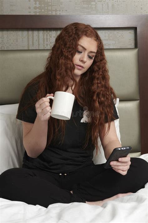 Young Redhead Woman In Bedroom Wearing Black Sweat Pants And T Shirt