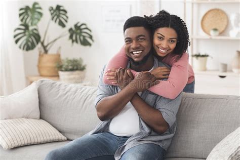 Happy Married Black Couple Cuddling At Home And Posing To Camera Stock