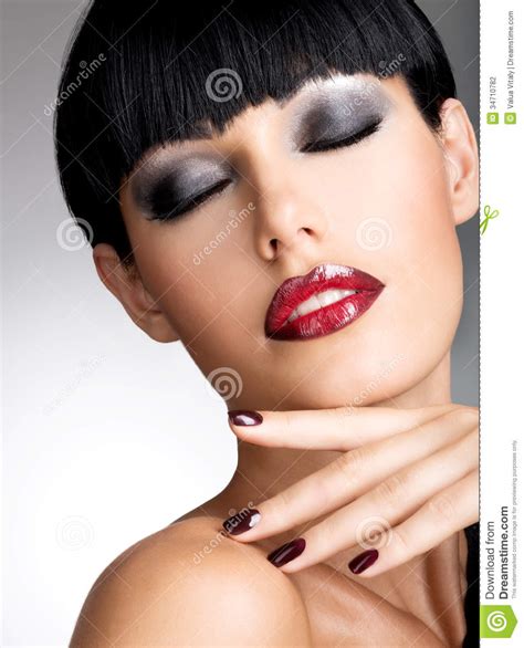 face of a woman with beautiful dark nails and stock