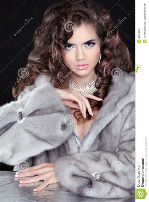 beautiful fashion brunette girl in mink fur coat isolated