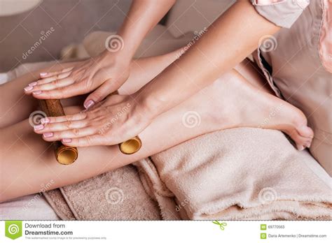 massage of human foot in spa salon with bamboo sticks stock image