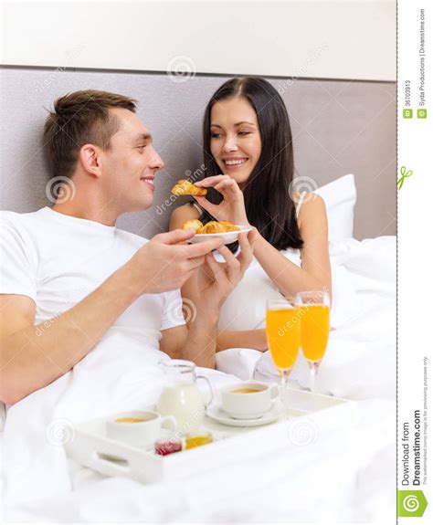 Smiling Couple Having Breakfast In Bed In Hotel Stock