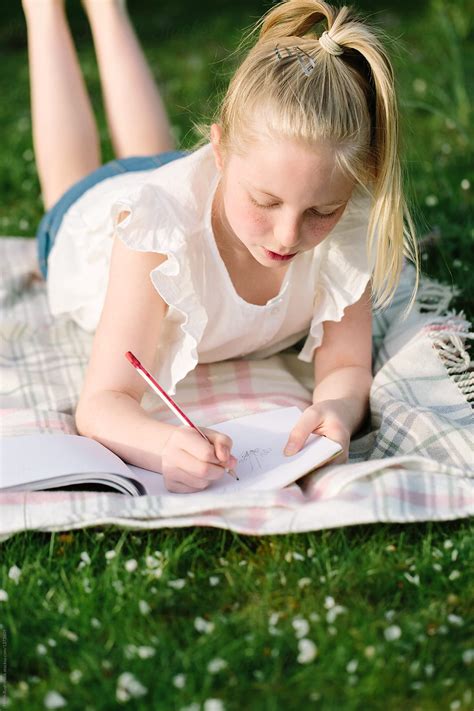 tween girl drawing outdoors in early summer by helen rushbrook