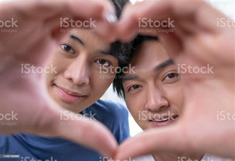 Young Asian Gay Couple In A Romantic Mood Making Heartshaped Hand