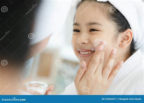 mother adding treatment cream   cheek  young  cute asian girl