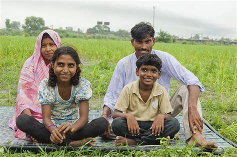 happy rural farmer family parents   children sitting  charpai