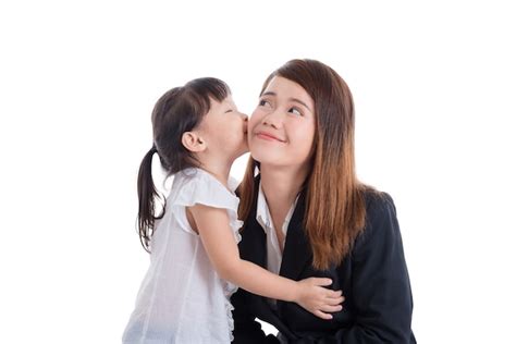 premium photo little asian girl kissing her mother over white background