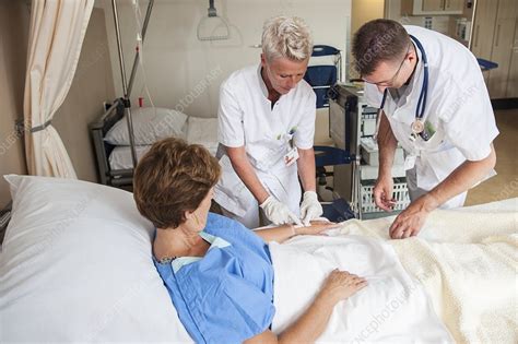 nurse preparing a patient for an iv line stock image