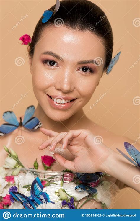 beautiful happy naked asian girl in flowers with butterflies on body