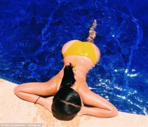 Kim Kardashian Shows Off Shapely Derriere While Sunbathing