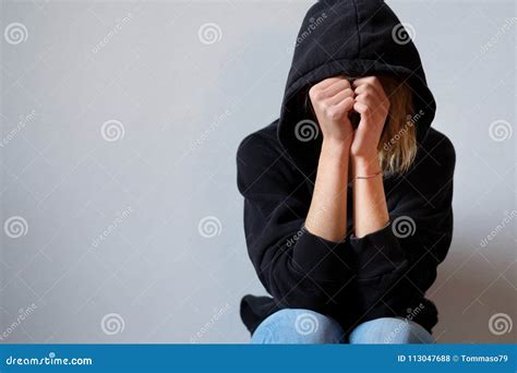 young girl hiding  face  hooded sweatshirt isolated   stock photo image  person