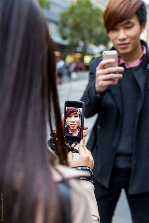 «young Chinese Couple Video Chatting Each Other On Street Del