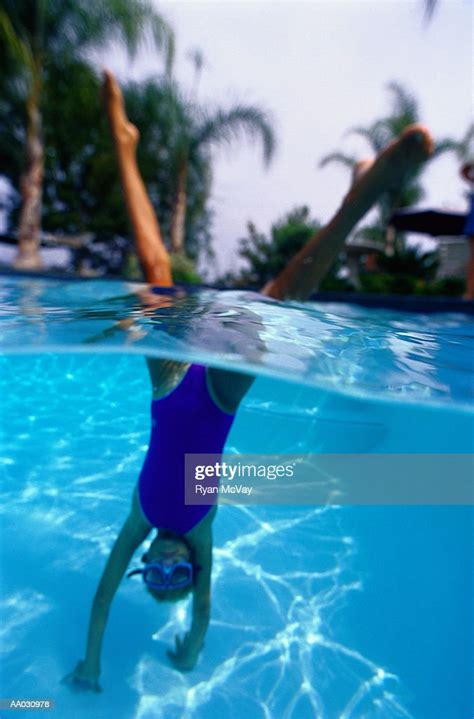 girl doing a handstand in a swimming pool photo getty images