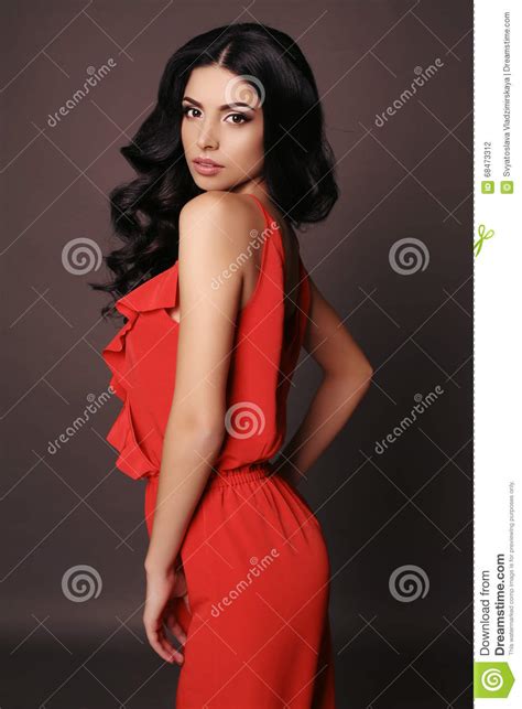Woman With Dark Hair And Evening Makeup Wears Elegant Red