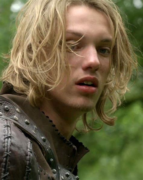 a man with long blonde hair wearing a leather jacket