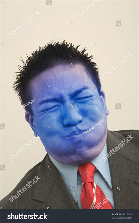 young businessman holding breath turning blue stock photo