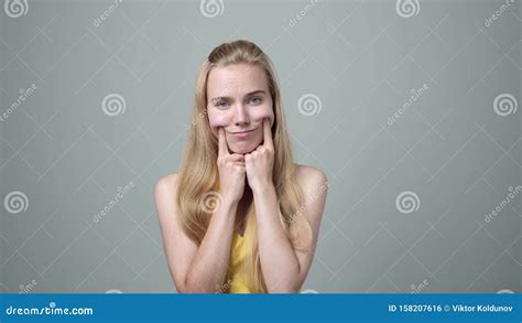 Young Woman Making Fake Smile With Fingers Stretching The Corners Of