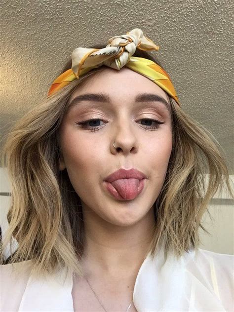 A Woman Sticking Her Tongue Out And Wearing A Headband With Bowknots On It