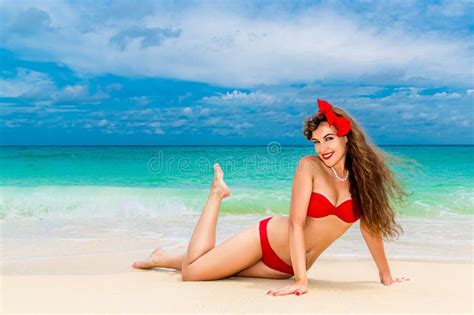 pin sulla bella giovane donna in bikini rosso su una spiaggia tropicale