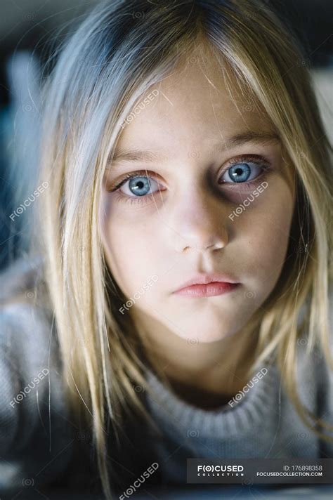 beautiful blonde preteen girl with big blue eyes looking