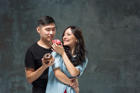 Un Jeune Joli Couple Asiatique Avec Un Verre De Jus Dorange Photo