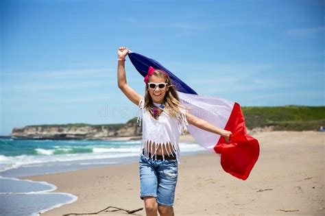 happy french girl carries fluttering blue white red french flag of