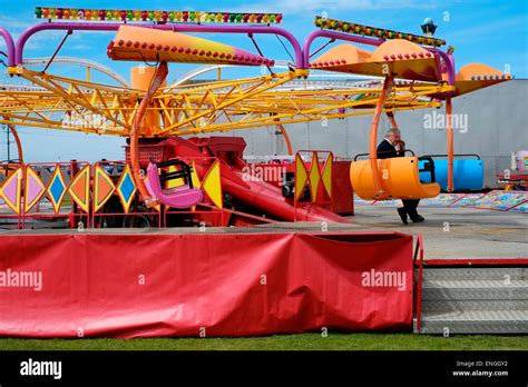 A Lone Male Sat On His Fairground Ride Waiting For Customers Stock