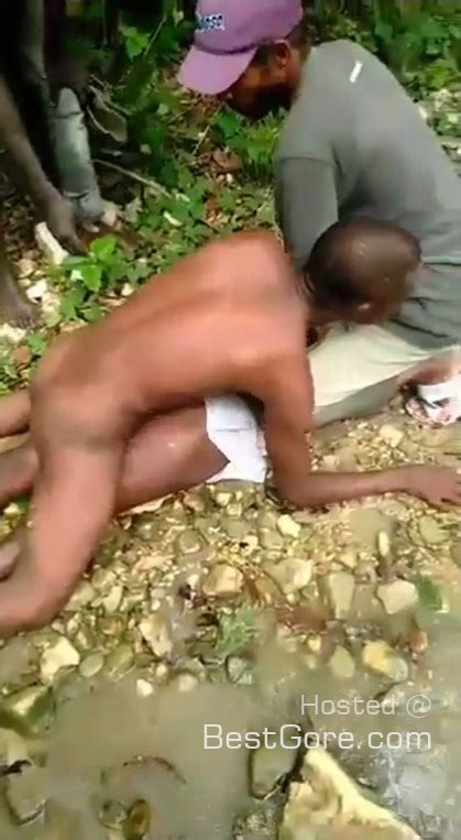a woman is pinned down and assaulted as villagers cheer on