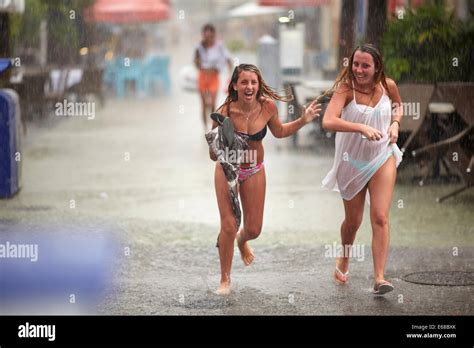 two women run through rain stockfotos and two women run through rain