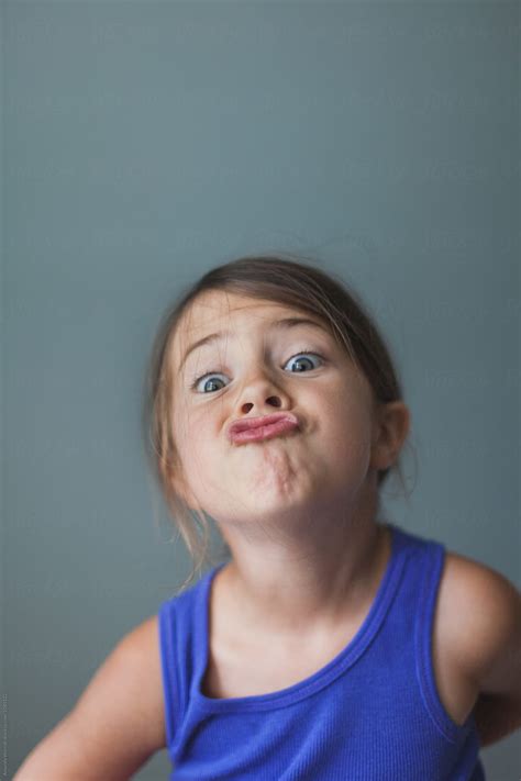 simple indoor portrait  young girl making  silly face  stocksy