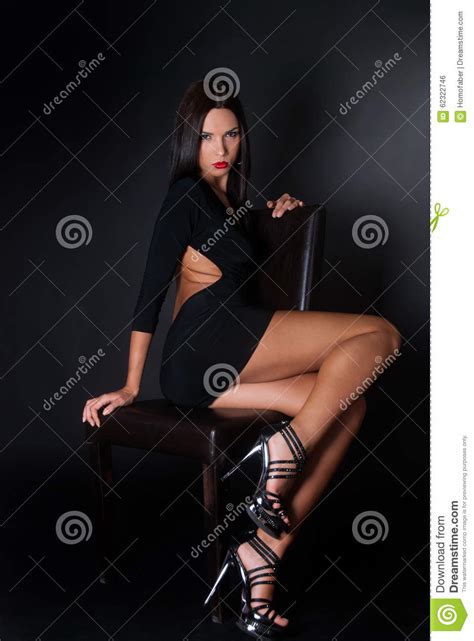 Attractive Brunette Wear Black Dress Sitting On Leather Chair Stock