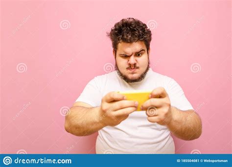 portrait   overweight young overweight man playing mobile games   sad faced smartphone