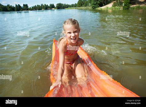 fröhliche kleine mädchen im see auf matratze stockfotografie alamy