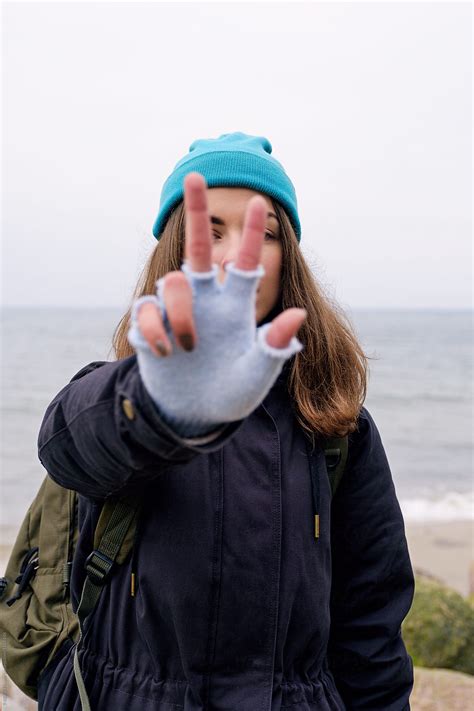 girl shows two fingers sign at beach by stocksy contributor danil