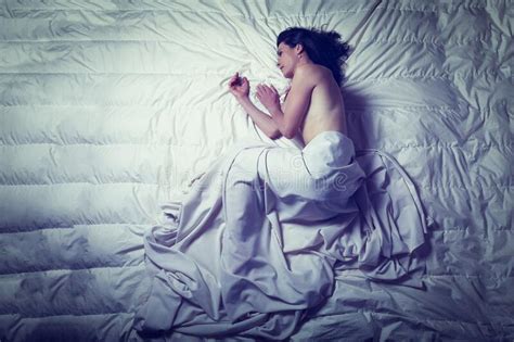 Conceptual Image Of A Woman Sad And Lone On A Bed Under A Sheet Stock
