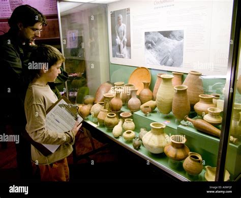 A Father And Son Looking At Display Of Egyptian Artifacts In The Egypt