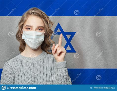 Woman In Medical Mask Pointing Up Against National Flag Israel